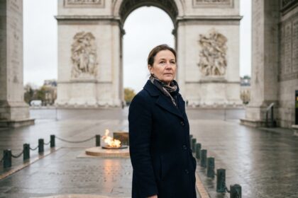 Femme en manteau navy devant la flamme éternelle de l Arc de Triomphe